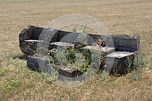 Log bench that had seating areas cut into it with the cut out pieces used as foot stools