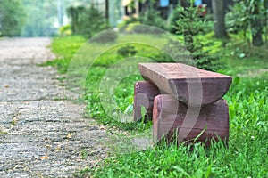A log bench in the Park against a background of green grass