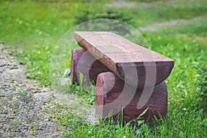 A log bench in the Park against a background of green grass