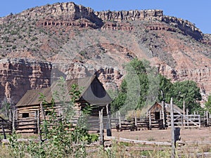 Log cabin and a barn house at the foot of a hill at Grafton ghost town, Utah