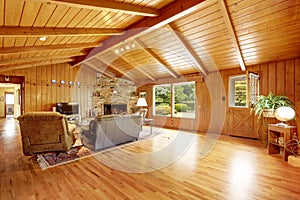 Log cabin house interior. Living room with fireplace and leather