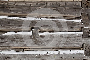 Log cabin sawn logs to corner closeup with snow in between