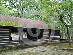 Log cabin shelter built at a park for recreational use