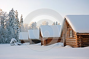 Log cabins under snow in winter