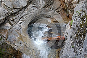 Log caught in rocky pool below Christine Falls