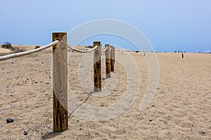 Log fence in a sandy shore on a sunny morning