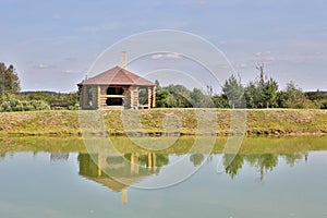 Log house on the lake with reflection