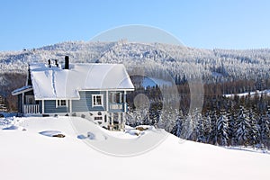 Log house in the snow in the sunhine