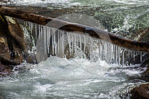 Log with icicles over a river