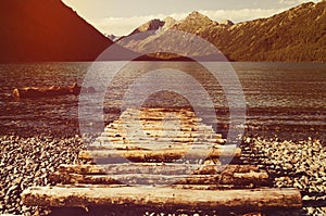 log wooden bridge on a background of lake and mountains