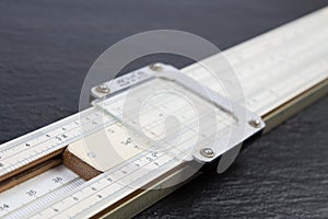 Logarithmic ruler on black background. Stationery for engineers and students