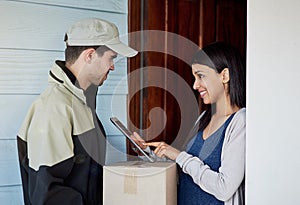 Logging her delivery as received. Cropped shot of a young woman using a digital tablet to sign for her delivery from the