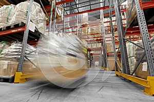 Worker carrying loader with goods at warehouse