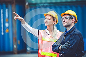 Logistic worker man and woman working team with radio control loading containers at port cargo to trucks for export and import