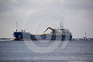 Logistics and transportation Cargo ship with ports crane bridge coming in port