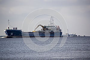 Logistics and transportation Cargo ship with ports crane bridge coming in port