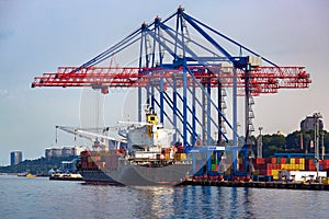 Logistics and transportation of container cargo ship with working crane.