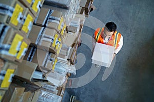 Logistics warehouse worker with a box in his hands.