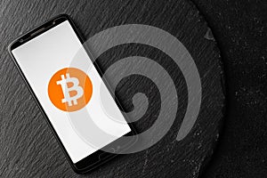 Logo of Bitcoin digital cryptocurrency money on the screen of a smartphone.
