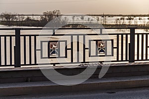 The logo of the city of Uralsk on the railing of a road bridge. Road bridge over the Ural River.