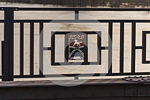 The logo of the city of Uralsk on the railing of a road bridge. Road bridge over the Ural River.