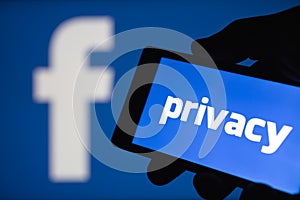 Logo of the Facebook blurred on background. The concept of privacy on popular social network. Shallow DOF