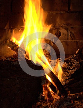Logs burning in a old brick fireplace