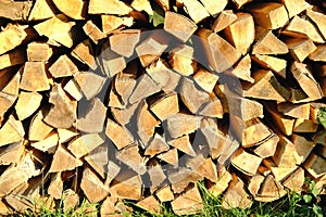 Logs of firewood chopped on logs in woodpile, logging for winter, concept stoking stove, fireplace, seasonal cooling in housing,