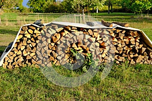 Logs of firewood chopped on logs in woodpile, logging for winter, concept stoking stove, fireplace, seasonal cooling in housing,