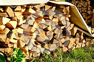 Logs of firewood chopped on logs in woodpile, logging for winter, concept stoking stove, fireplace, seasonal cooling in housing,