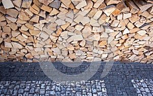 Logs stacked horizontally on mosaic pavement