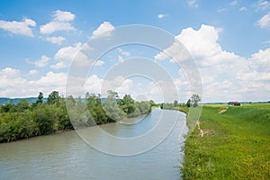 Loisach river with green riverbanks and cloudy sky