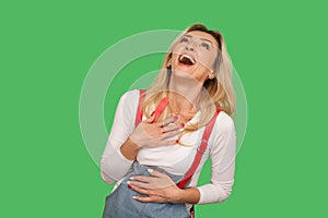 Lol, crazy hilarious laughter. Portrait of adult blond woman in stylish denim overalls laughing out loud