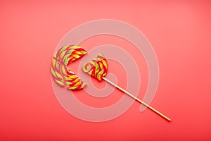 Lollipop broken into pieces on pink background, top view with copy space