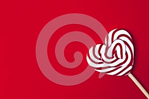 Lollipop in the shape of a heart, on a red background, Valetine, no people, horizontal,