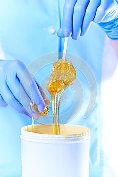 Lollipop in a stretchy clear golden luminous sugaring paste for depilation photo