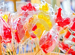 Lollipops cockerels on sticks yellow and red colors. Street food