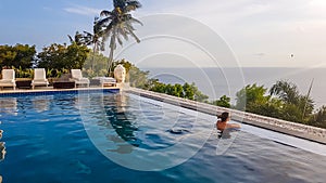 Lombok - A woman enjoying the sunset in an infinity pool