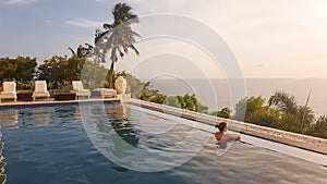 Lombok - A woman enjoying the sunset in an infinity pool