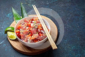 Lomi lomi salmon, hawaiian raw salmon salad on blue background