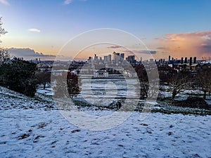 London city centre view from greenwich hill snow winter blue sky orange warm light sunset sundown skyline skyscraper uk