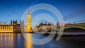 London, England - The Big Ben Clock Tower and Houses of Parliament with iconic red double-decker buses at city of westminster by