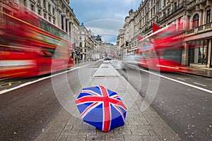 London, England - British umbrella at busy Regent Street with iconic red double-decker buses