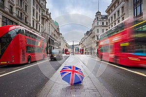 London, England - British umbrella at busy Regent Street with iconic red double-decker buses