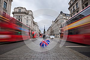 London, England - British umbrella at busy Regent Street with iconic red double-decker buses