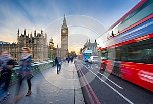London, England - The iconic Big Ben and the Houses of Parliament with famous red double-decker bus and tourists
