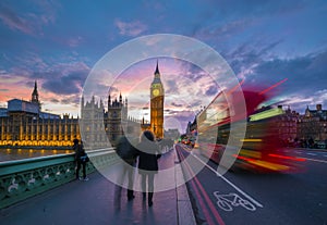 London, England - Iconic Red Double Decker Bus on the move on Westminster Bridge with Big Ben and Houses of Parliament