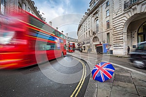 London, England - Iconic red double-decker buses and black taxi on the move on Regent Street