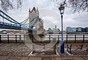 London, England - Iconic Tower Bridge with bench and street light on a cloudy day