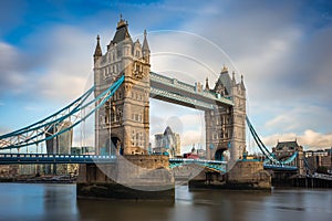 London, England - Iconic Tower Bridge with traditional red double-decker bus and skyscrapers of Bank District